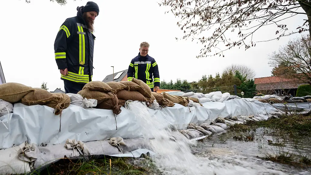 Ehrenamtliche-Einsatzkraefte-kontrollieren-in-einem-Wohngebiet-das-Abpumpen-von-Wasser