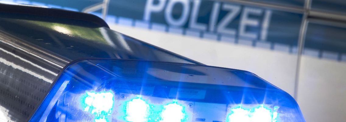 Ein Blaulicht leuchtet während eines Einsatzes auf dem Dach eines Polizeiwagens.