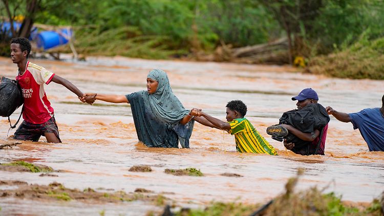 Im kenianischen Nairobi kämpfen sich Anwohner über eine durch Regenfälle beschädigte Straße. 