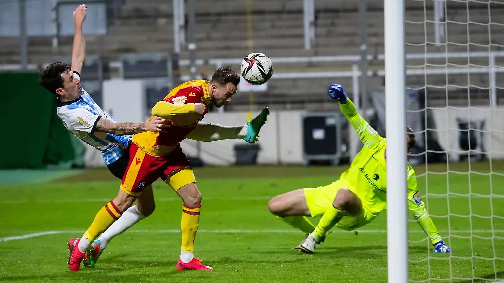 Lucas-Cueto-M-von-Karlsruhe-spielt-gegen-Kevin-Goden-l-und-Torwart-Marco-Hiller-von-Muenchen-den-Ball-ins-Tor