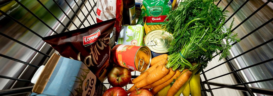 Lebensmittel liegen in einem Einkaufswagen in einem Supermarkt.