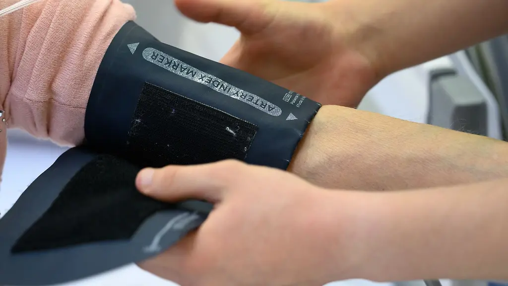 Ein-Pflegeabsolvent-in-einem-Krankenhaus-beim-Anlegen-eines-Blutdruckmessgeraetes