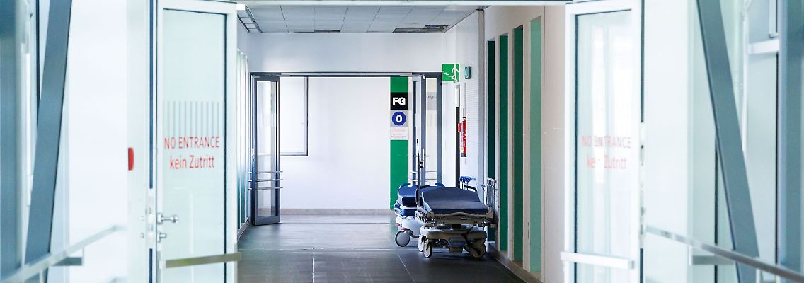 Krankenbetten stehen in einem Gang in einem Krankenhaus.