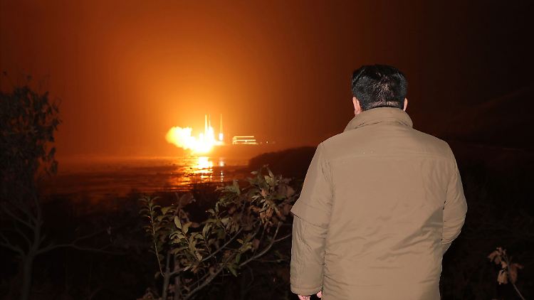 Nordkoreas Machthaber Kim Jong Un beim Beobachten des Starts einer Rakete vom Typ "Chollima-1", die einen Aufklärungssatelliten in All befördert hat. 