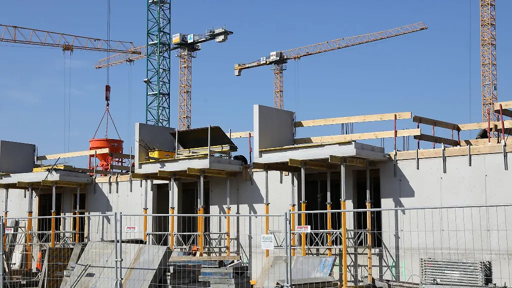 Kraene-und-Gerueste-stehen-auf-der-Baustelle-eines-Mehrfamilienhauses