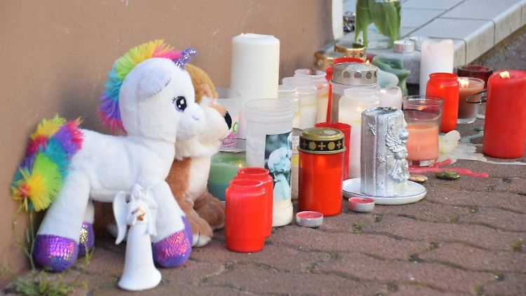 Plüschtiere und Kerzen stehen vor einem Haus in Hockenheim, in dem eine Frau ihre beiden Söhne getötet haben soll.