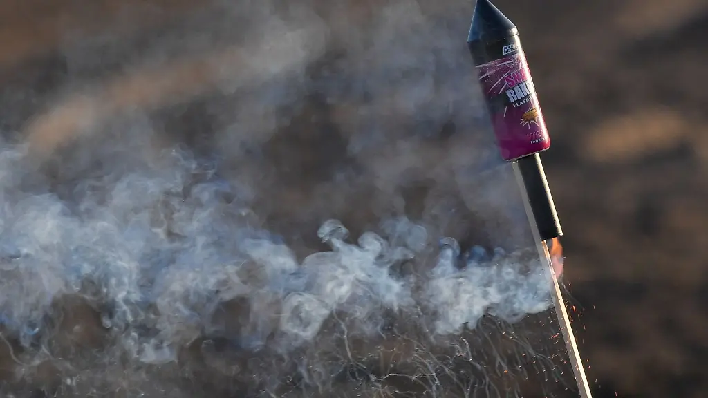 Eine-angezuendete-Silvester-Rakete-steckt-im-Boden