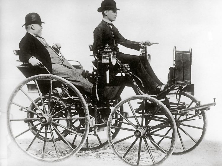 Gottlieb Daimler (hinten) in einem von ihm konstruierten Automobil, Bild von 1886.