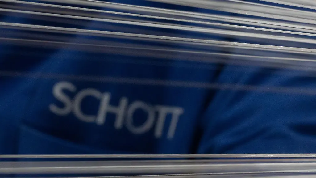 Eine-Mitarbeiterin-der-Schott-AG-arbeitet-in-der-Abteilung-Lighting-and-Imaging-des-Glas-Technologiekonzerns-Schott-AG-an-einer-Maschine-die-einzelne-Glasfasern-zu-einem-Rohfaserbuendel-zusammenfasst