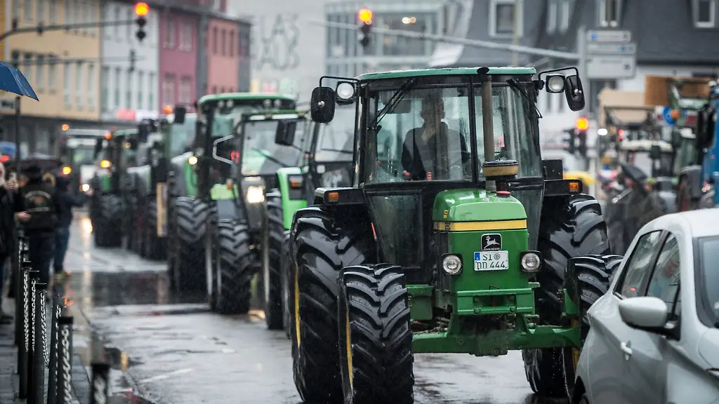 Zahlreiche-Traktoren-sind-auf-einer-Strasse-zu-sehen