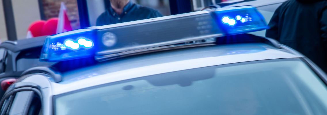 Ein Streifenwagen der Polizei ist mit Blaulicht im Einsatz.