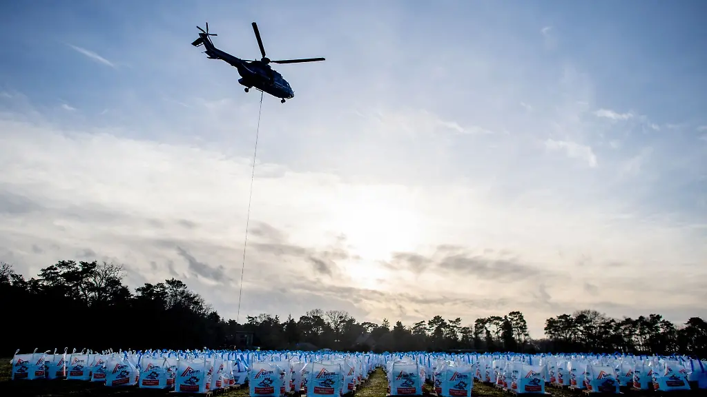 Ein-Hubschrauber-vom-Typ-Super-Puma-der-Bundespolizei-ist-am-Barnefuehrer-Holz-im-Einsatz-um-einen-Deich-mit-grossen-Sandsaecken-zu-sichern