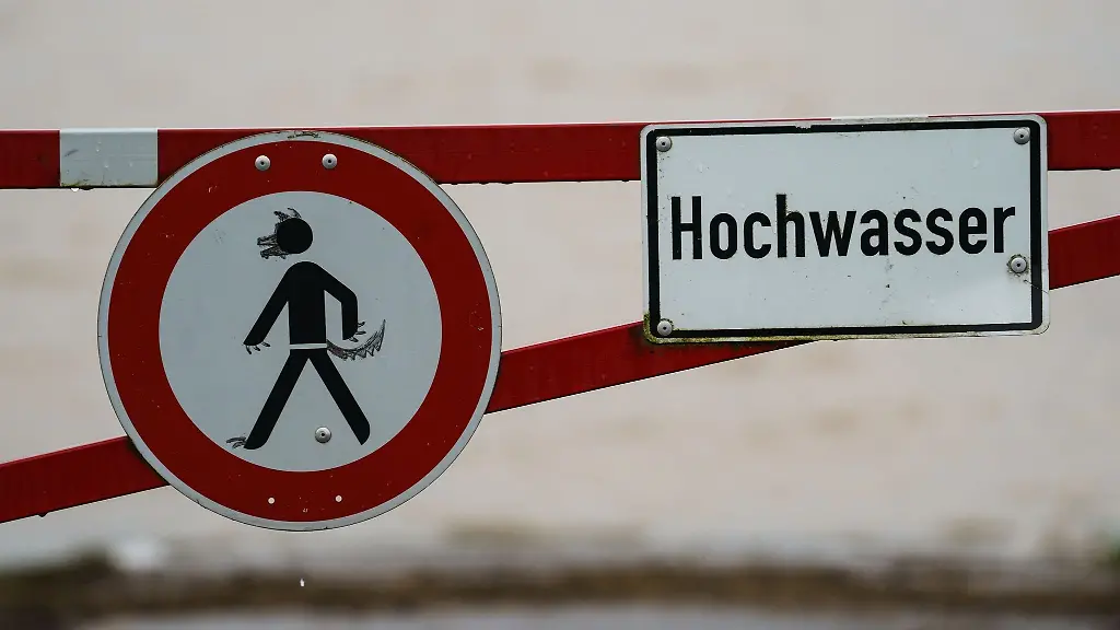 Ein-Hochwasser-Schild-steht-an-einem-ueberfluteten-Feld