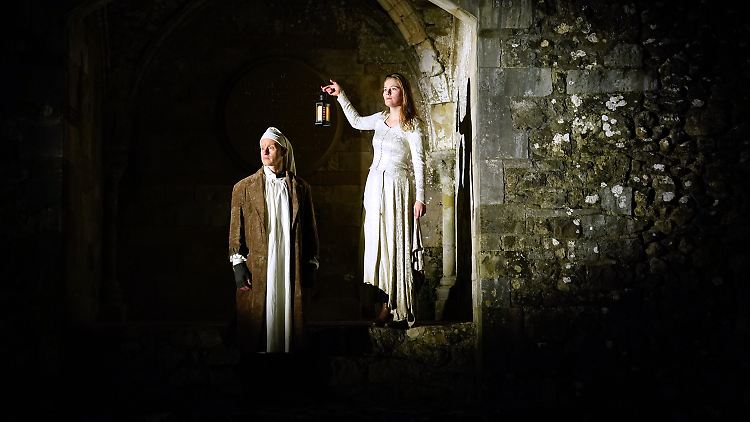 Schauspieler der "London Touring Players" sind in den Rollen von Ebenezer Scrooge und dem Geist der vergangenen Weihnacht bei der Generalprobe von"A Christmas Carol" in den Ruinen von Beaulieu Abbey in Hampshire zu sehen.
