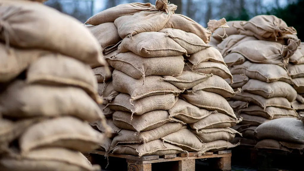 Zahlreiche-Sandsaecke-stehen-auf-einem-Parkplatz-fuer-Anwohner-im-Bereich-der-Hunte-am-Achterdiek-bereit