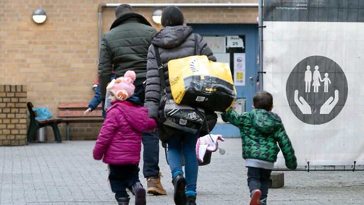 Eine geflüchtete Familie vor der Erstaufnahmeeinrichtung des Landesamtes für Flüchtlingsangelegenheiten (LAF) in Berlin-Reinickendorf.