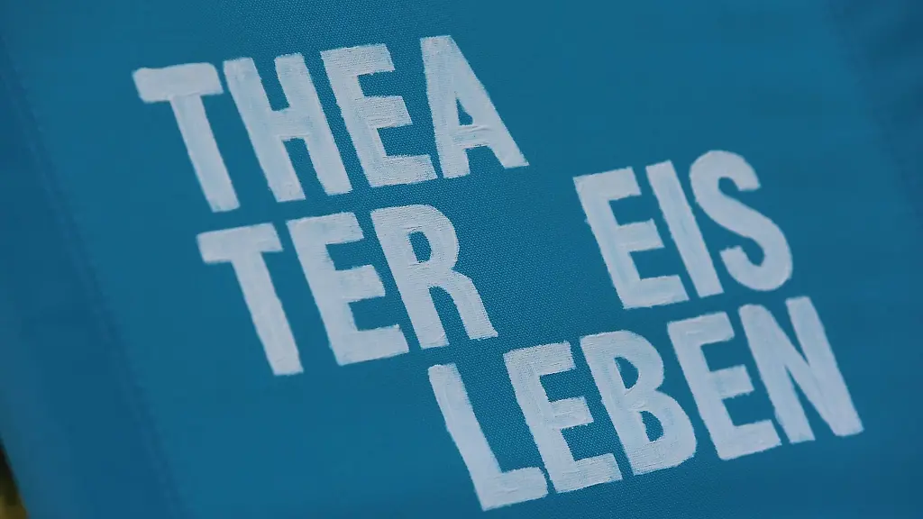 Ein-Klappstuhl-mit-der-Aufschrift-Theater-Eisleben-steht-auf-einer-Wiese