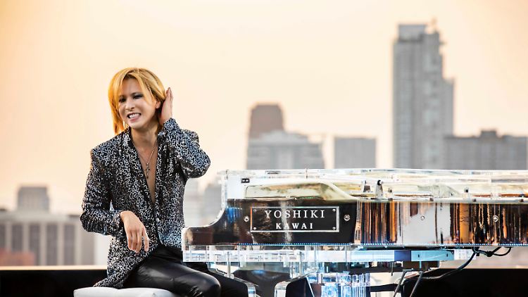 Yoshiki unter freiem Himmel an seinem gläsernen Piano.
