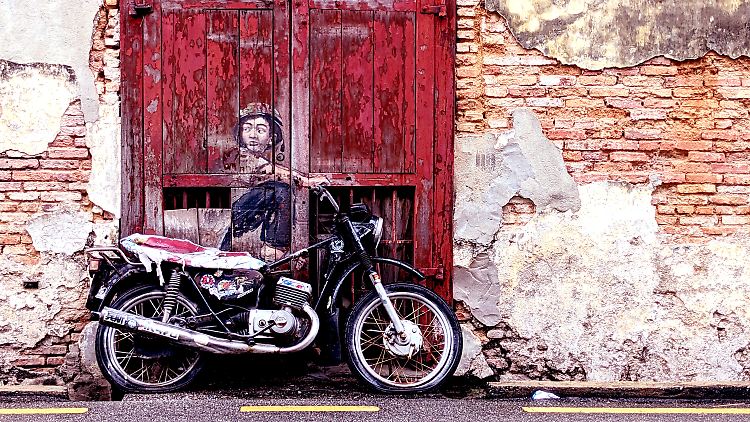 Das Street-Art-Kunstwerk "Boy on Motorbike" von Ernest Zacharevics an der Ah Quee Street in Penang.