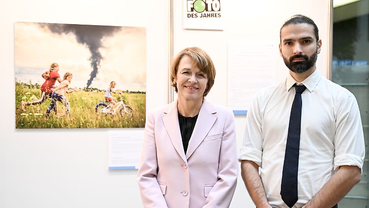 Das Werk im Hintergrund, davor UNICEF-Schirmherrin Elke Büdenbender und der Fotograf Patryk Jaracz.