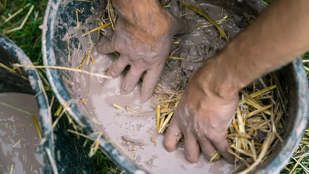 Ein-Mann-beim-Vorbereiten-einer-Stroh-Lehm-Mischung