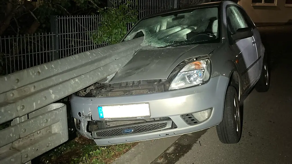 Ein-von-einer-Leitplanke-durchbohrtes-Auto-steht-nach-dem-Unfall-am-Strassenrand
