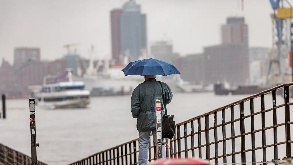 Nach-dem-Sturm-Zoltan-geht-ein-Mann-bei-Nieselregen-und-Windstille-am-Holzhafen-spazieren