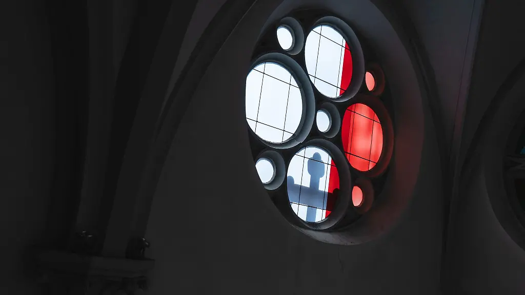 Licht-wirft-den-Schatten-eines-Kreuzes-durch-ein-Kirchenfenster