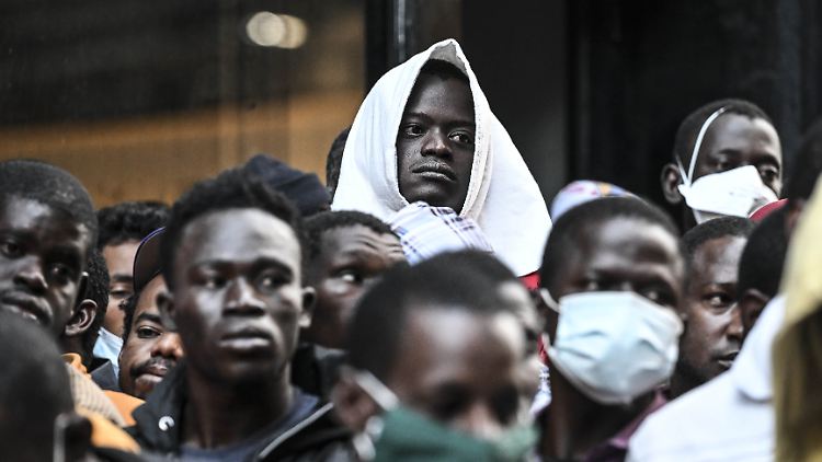 Migranten warten in New York vor einer Notunterkunft -  die Stadtverwaltung hat bereits Hotels umfunktioniert oder Zeltstädte in Parks und auf Freiflächen errichtet.