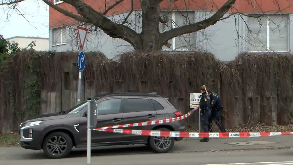 Polizeibeamte-nehmen-mit-Flatterband-eine-Absperrung-vor