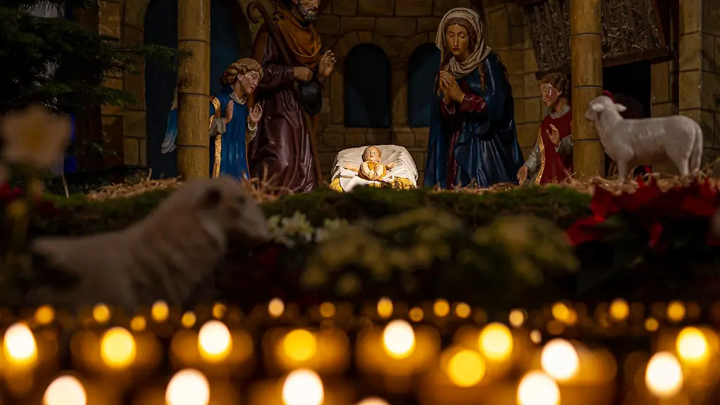 Eine-Weihnachtskrippe-steht-im-Osnabruecker-Dom-hinter-brennenden-Kerzen