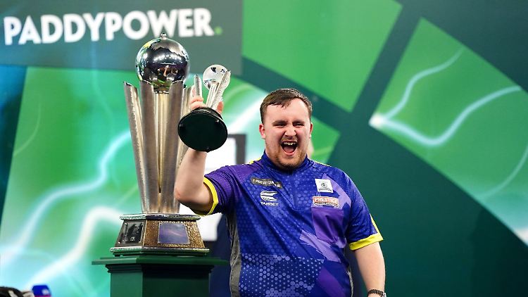 Luke Littler jubelt mit dem Pokal für den zweiten Platz.