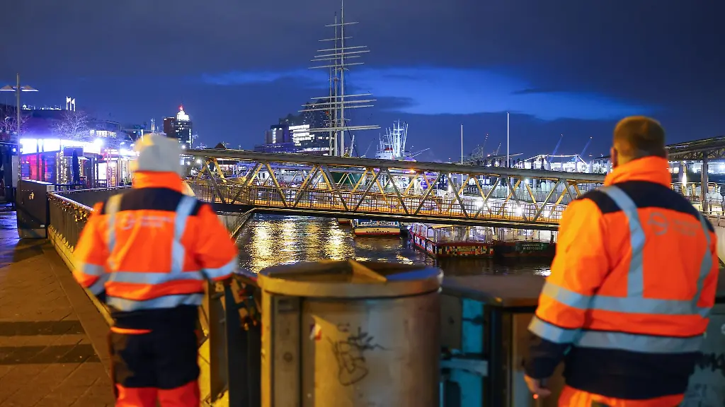 Zwei-Mitarbeiter-von-Hamburg-Wasser-zustaendig-fuer-die-Flutschutztore-stehen-an-den-Landungsbruecken