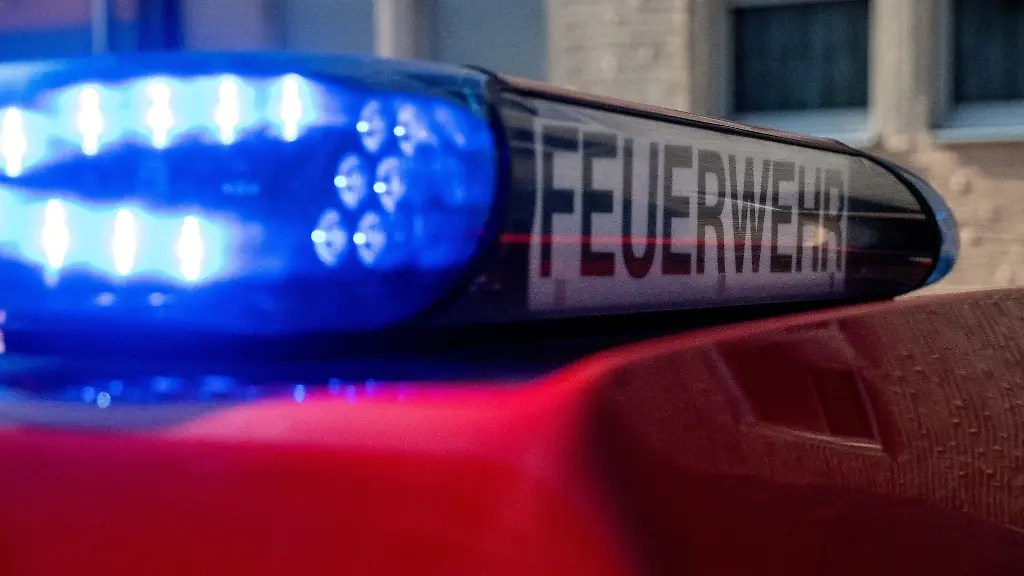 Ein-Feuerwehrfahrzeug-steht-mit-eingeschaltetem-Blaulicht-an-einem-Einsatzort