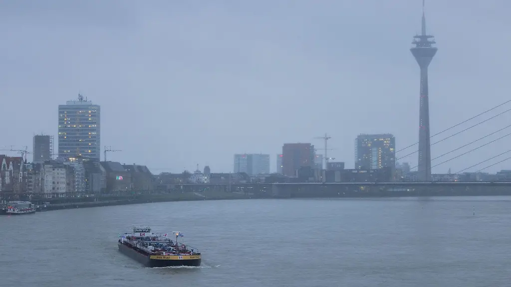 Ein-Schiff-faehrt-bei-steigendem-Pegel-ueber-den-Rhein-an-der-Duesseldorfer-Altstadt-vorbei