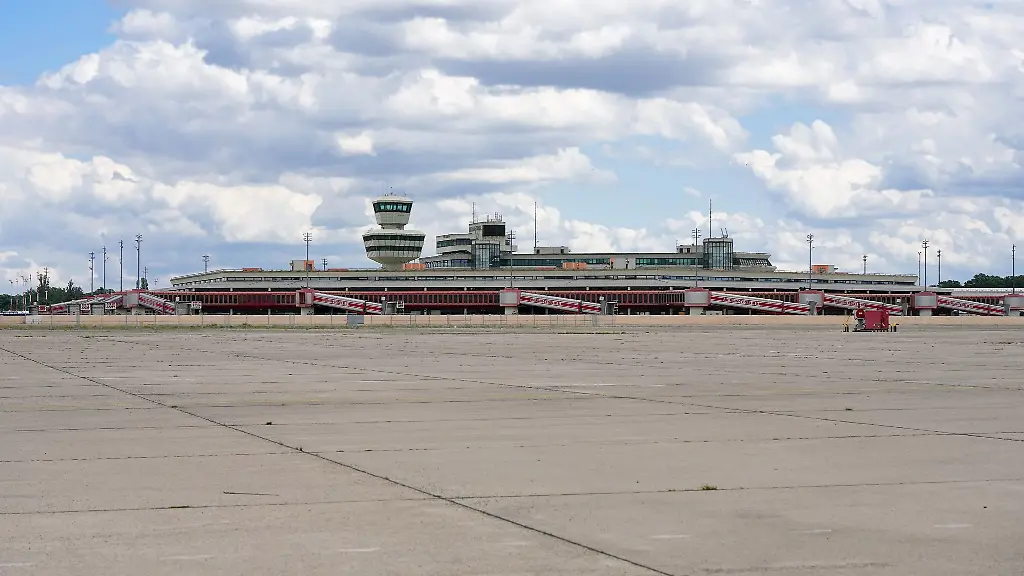 Ein-Zaun-aus-Holz-ist-um-die-Abfertigungshallen-und-den-Tower-des-ehemaligen-Flughafens-Berlin-Tegel-gezogen