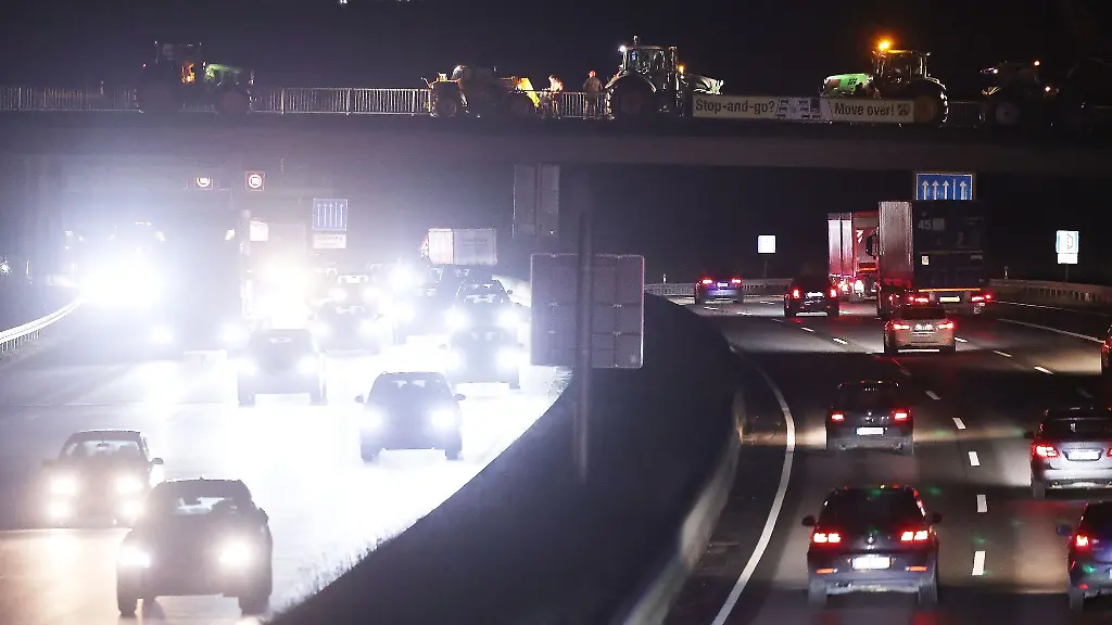 Landwirte-stehen-mit-Traktoren-auf-einer-Bruecke-ueber-der-A3