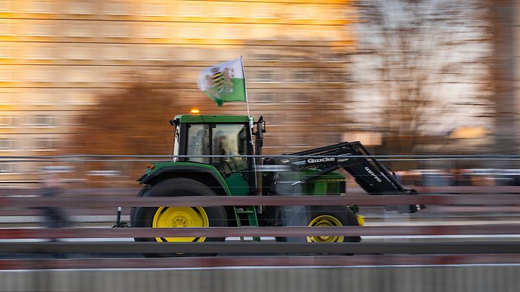 Nicht unterwandert? Ein Traktor fährt durch Dresden und hat dabei eine Fahne des einstigen Königreiches Sachsen, die häufig von Anhängern der rechtsextremen Kleinstpartei "Freie Sachsen" mitgeführt wird, am Fahrerhaus montiert. 
