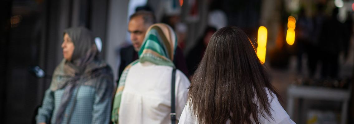 Eine Frau läuft im Juli 2023 mit offenen Haaren durch Teheran. Vor mehr als einem Jahr hatte der Tod der jungen Kurdin Jina Mahsa Amini die bislang schwersten Proteste in der Geschichte der Islamischen Republik ausgelöst. Viele Frauen zeigten sich daraufhin ohne Kopftuch in der Öffentlichkeit.