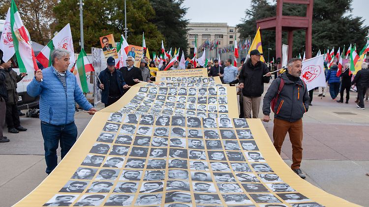 Protestierende tragen Porträts von Gegnern des iranischen Regimes vor dem europäischen Hauptsitz der Vereinten Nationen.