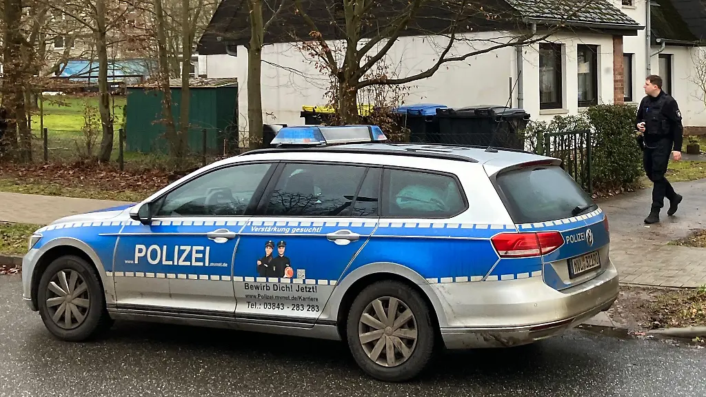 Ein-Polizeiauto-steht-vor-einem-Haus