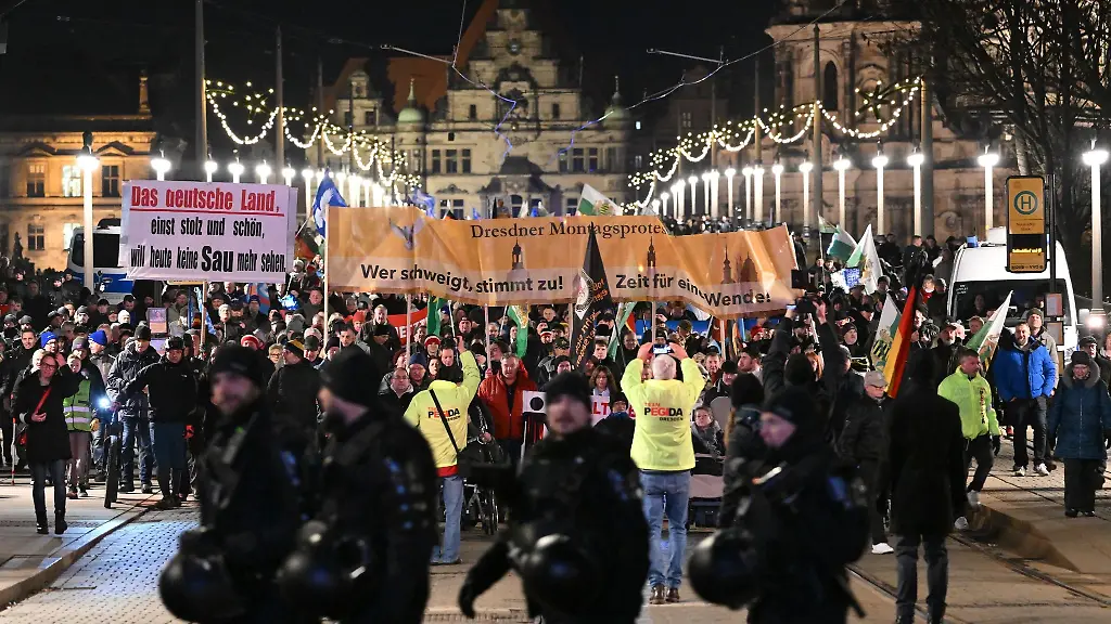 Teilnehmer-einer-Demonstration-der-rechtsextremistischen-Bewegung-Pegida-laufen-ueber-die-Augustusbruecke