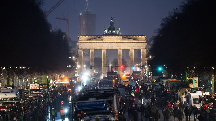 Schon am Sonntagabend stehen zahlreiche Bauern mit Traktoren vorm Brandenburger Tor.