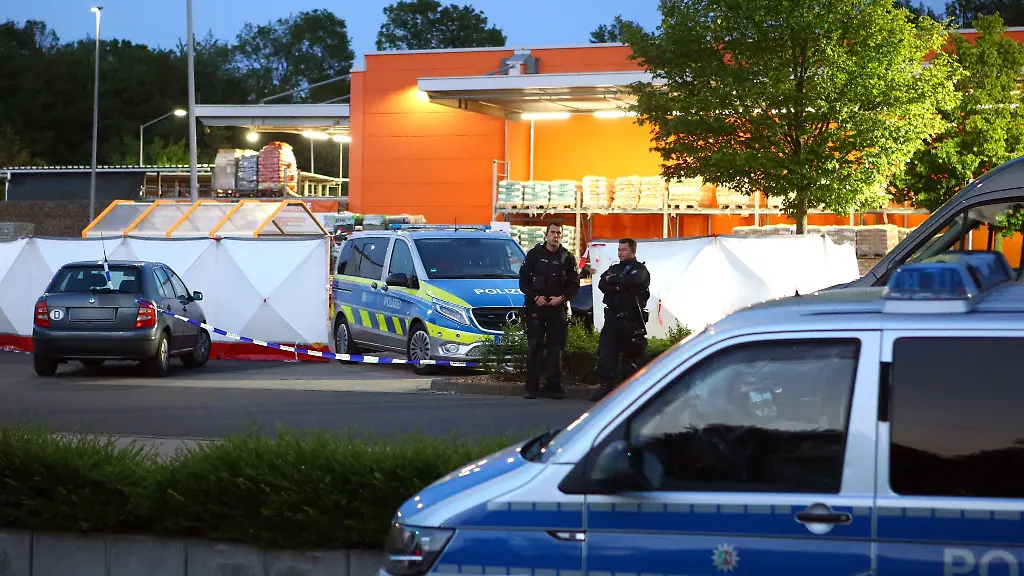 Polizisten-stehen-am-Tatort-auf-dem-Parkplatz-eines-Baumarkts