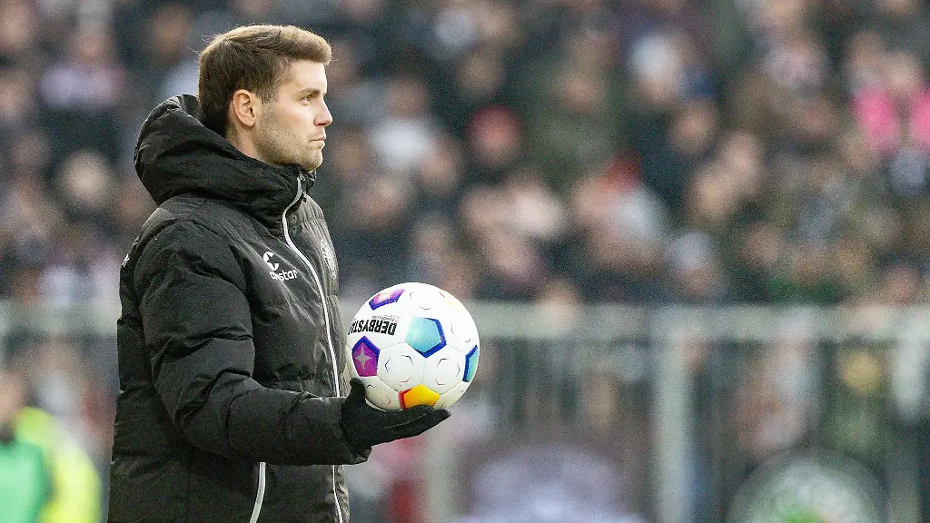 Paulis-Trainer-Fabian-Huerzeler-haelt-einen-Ball-an-der-Seitenlinie