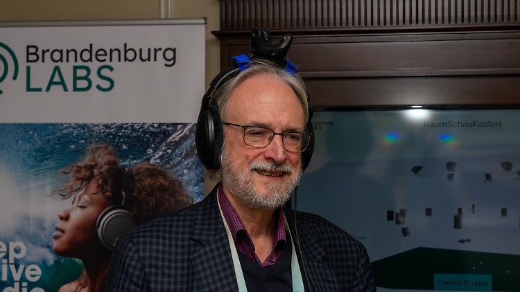 Karlheinz Brandenburg trägt Sennheiser-Kopfhörer mit HTC-Vive-Tracker am Bügel.