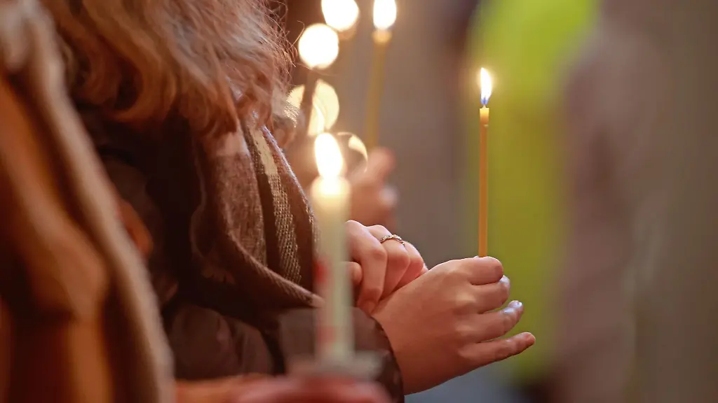 Teilnehmer-eines-oekumenischen-Gottesdienstes-halten-Kerzen-die-das-Friedenslicht-aus-Betlehem-symbolisieren