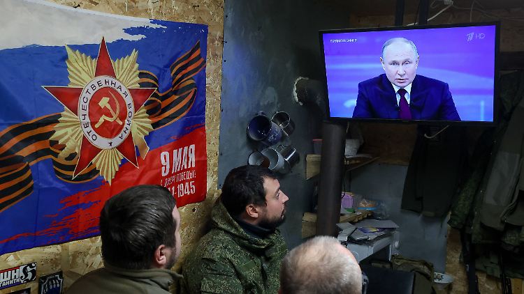 In der Region Saporischschja stationierte russische Soldaten verfolgen einen Fernsehauftritt von Präsident Wladimir Putin.  