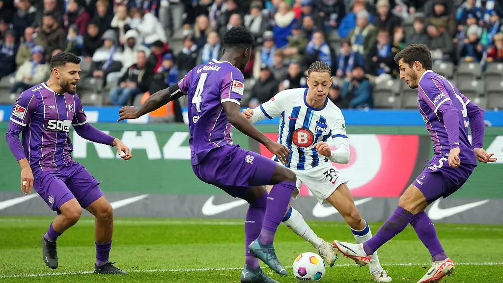 Herthas-Derry-Scherhant-2-v-r-versucht-sich-gegen-Osnabruecks-Spieler-Bashkim-Ajdini-r-und-Maxwell-Gyamfi-2-v-l-durchzusetzen