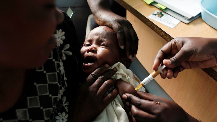 Eine Mutter hält ihr Baby, das 2009 im Rahmen einer Studie in Kenia einen neuen Malaria-Impfstoff erhält.